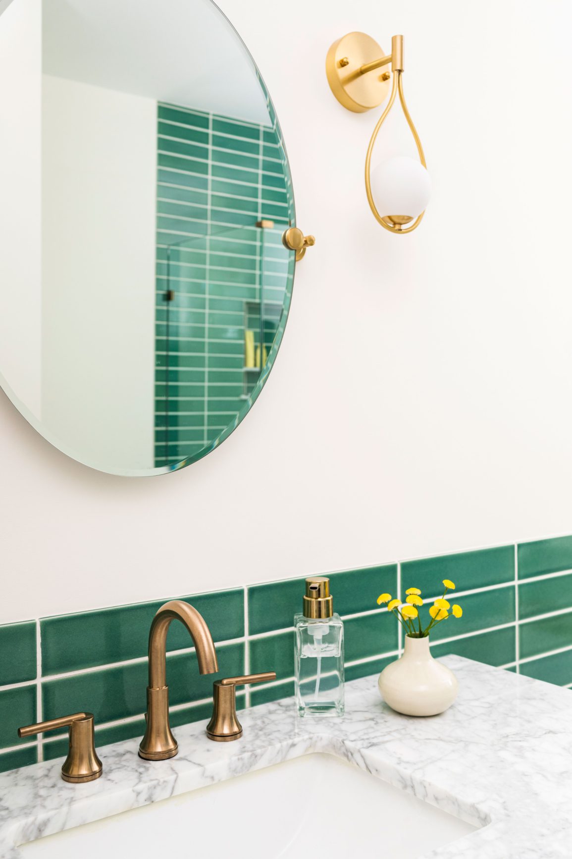 Green tiled bathroom with sconce
